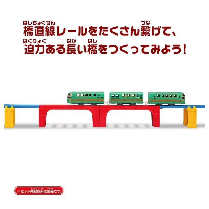  A toy train set with a green train on a red and blue bridge.