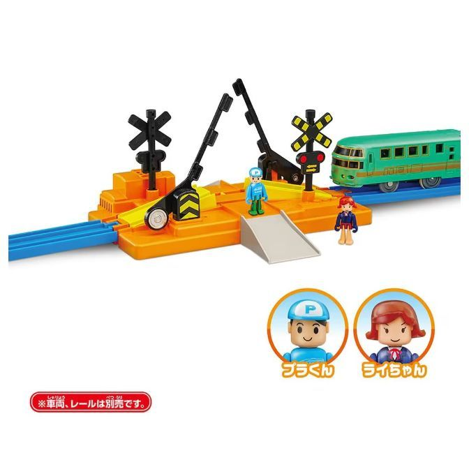  A toy train set with a crossing gate, a train, and two figures.
