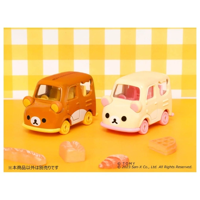  Two Rilakkuma toy cars, one brown and one cream, with bread-shaped toys on a yellow surface.