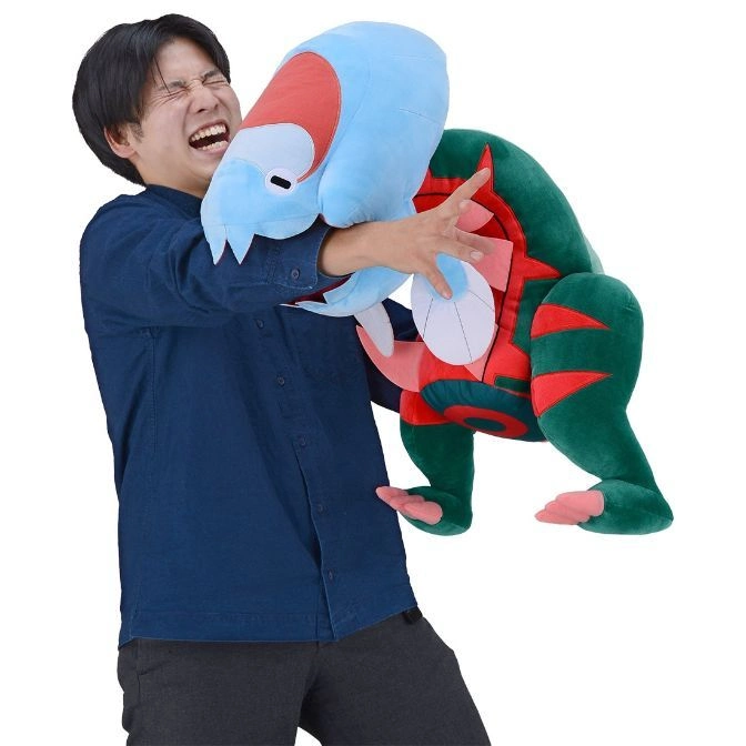  Man playfully struggles with a plush Paldean Tauros toy, featuring blue head and green body.