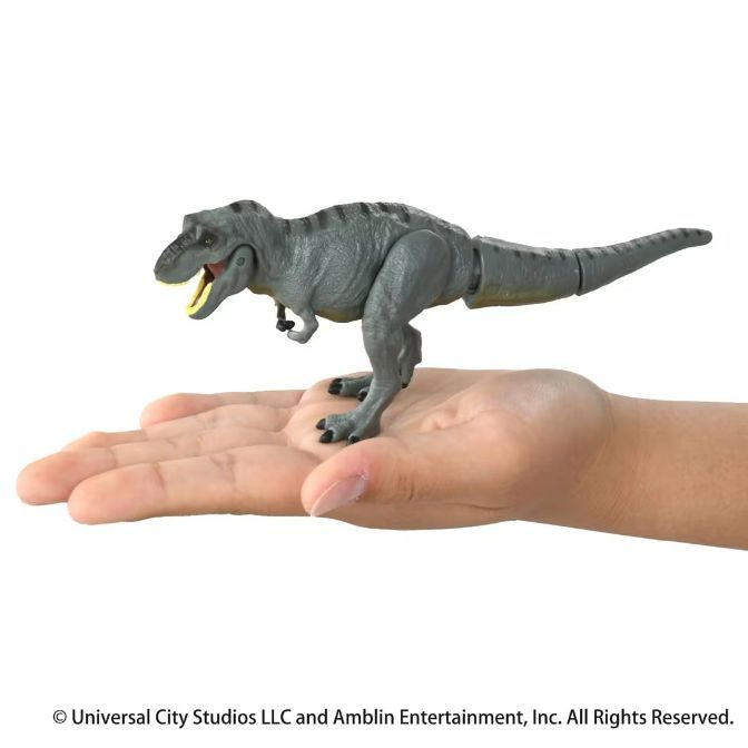  Grey T-Rex toy with articulated tail on a hand.