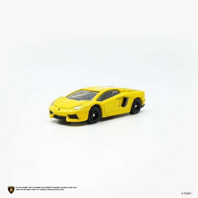  Yellow toy Lamborghini Aventador with black wheels on a white surface.