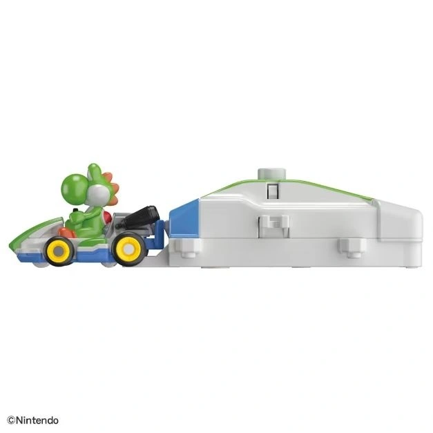 Yoshi in a kart towing a white trailer with green trim and blue accents, a toy from Nintendo.