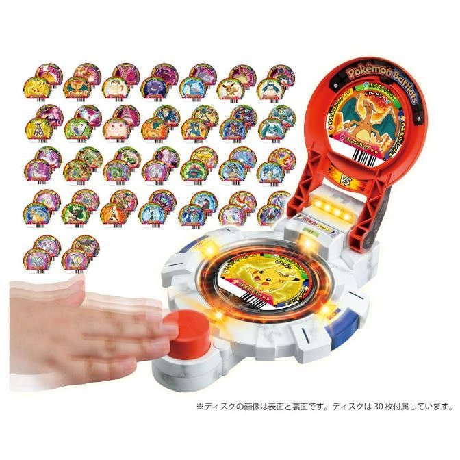 Pokémon Battlers toy with discs. Hand presses button. Charizard and Pikachu cards visible.