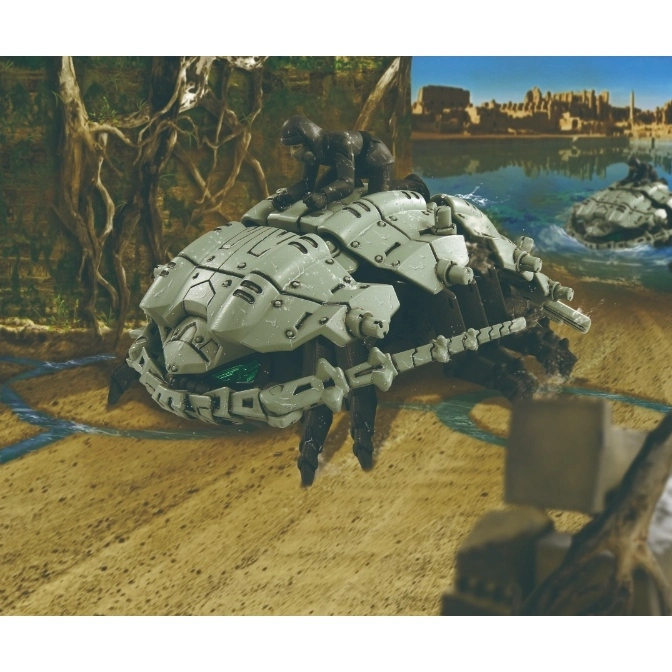  Toy crab tank with a figure on top, crawling on a beach with another in the water.