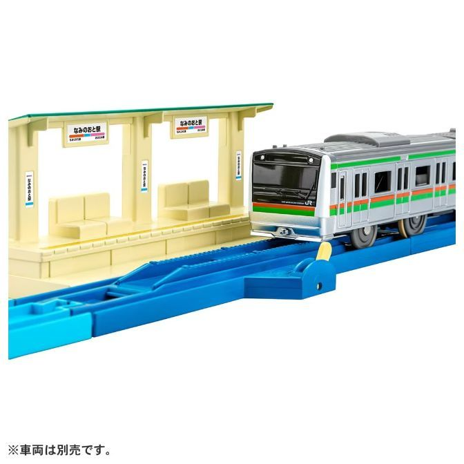  A toy train set with a train, station, and tracks.