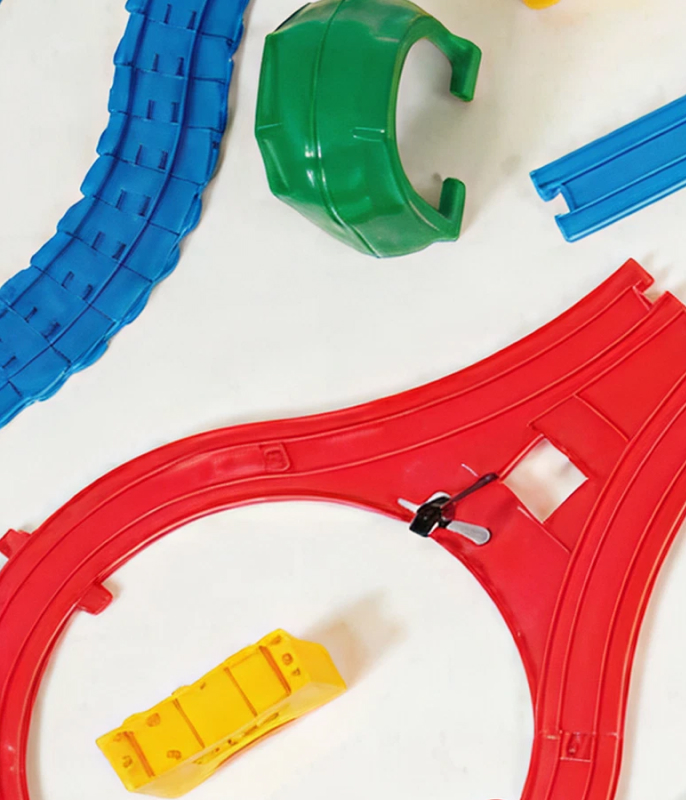 Colourful Plarail track pieces on white background.
