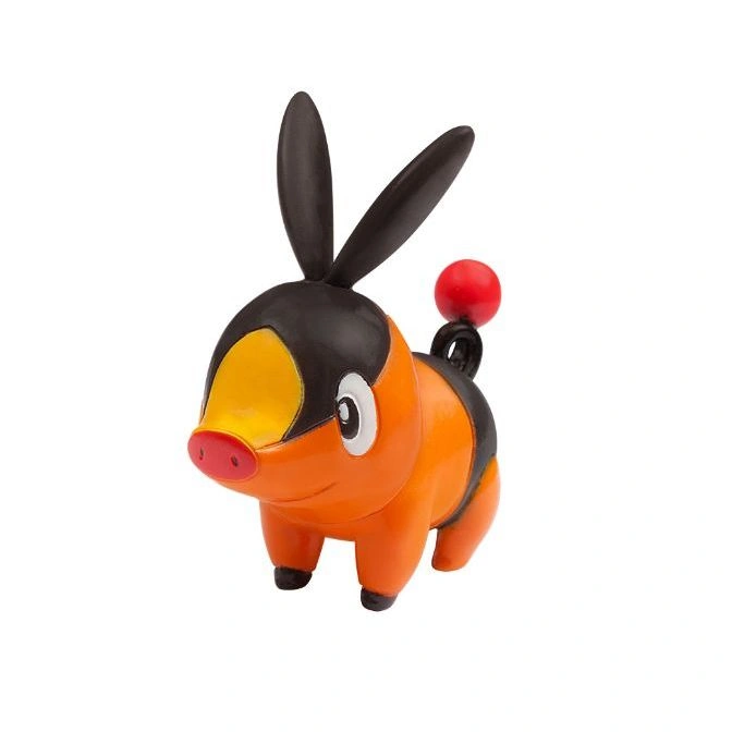 Tepig toy figure with orange body, black head, bunny ears, and a red ball on its tail.