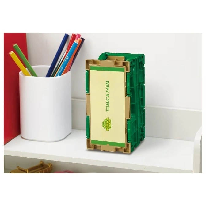  Green Tomica Farm toy crate with a tan label, sitting on a white shelf.