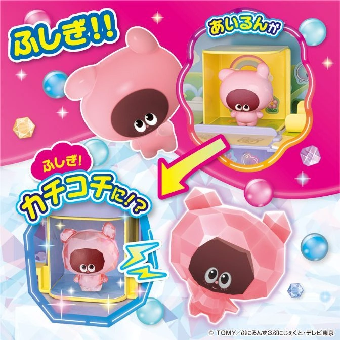  Pink bear toy transforms from smooth to faceted inside a playset, surrounded by colorful spheres and gems.