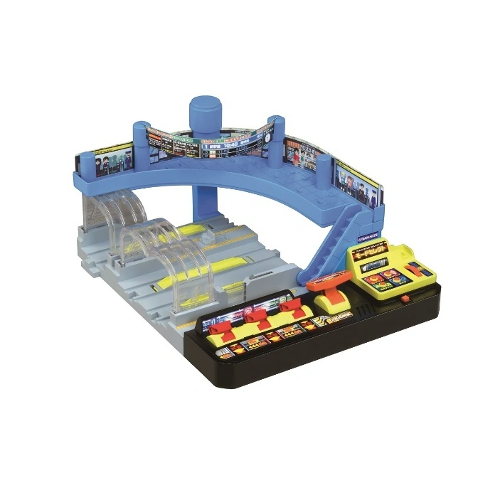 Toy train station with elevated platform, control panel, and train tracks.