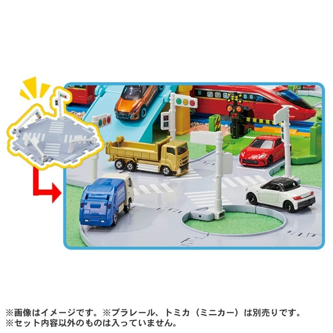  Toy train set with cars, trucks, traffic lights, and a train on a blue track.