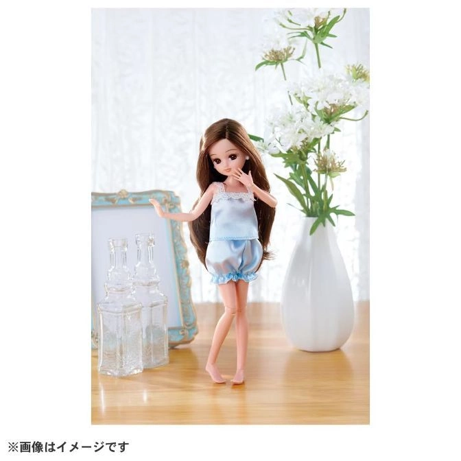  Licca-chan doll in blue pajamas standing near flowers and glass bottles.