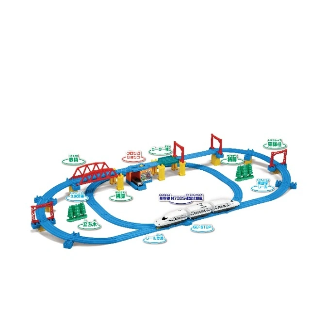 Toy train set with a white bullet train on blue tracks, featuring bridges, trees, and a station.