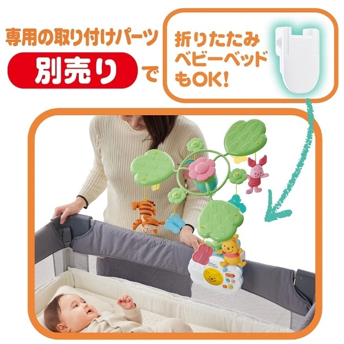  Winnie the Pooh crib mobile with hanging characters, attached to a baby cot with a baby inside.