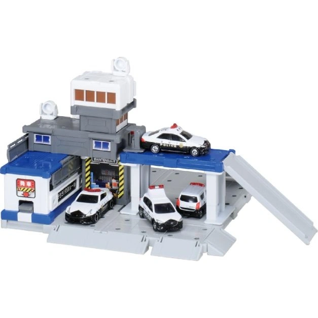  Toy police station with three toy police cars parked inside and one on the roof.