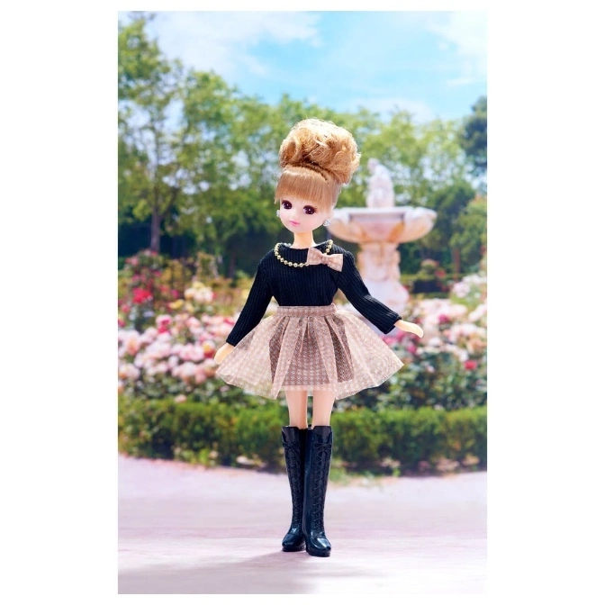  Licca-chan doll in black top, tulle skirt, and boots, standing in a garden.