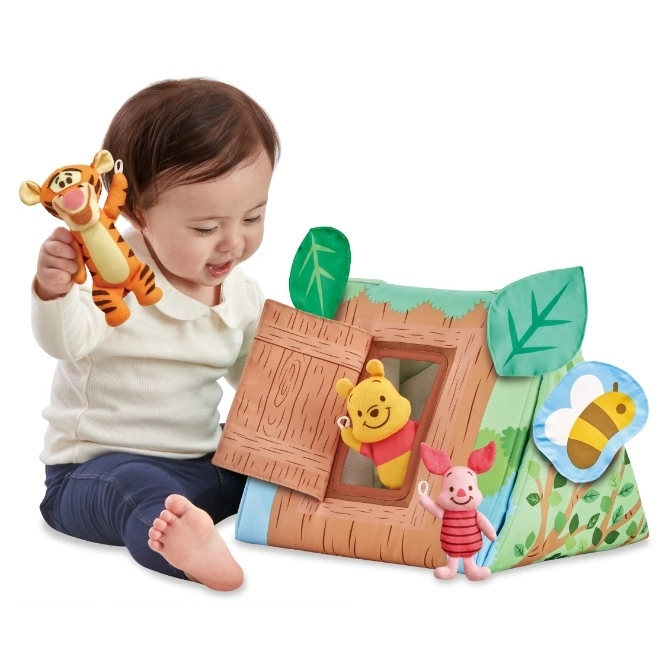  Baby playing with a Winnie the Pooh house playset and Tigger plush toy.