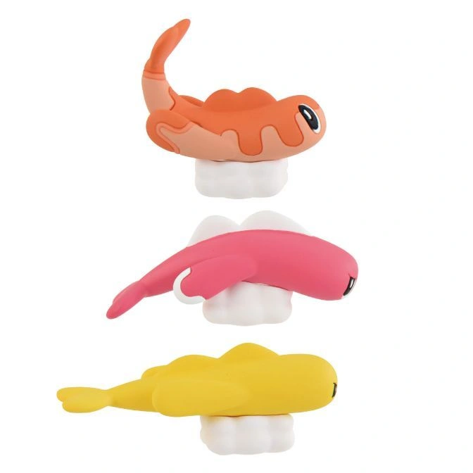  Stack of three colorful toy fish figures on white bases: orange, pink, and yellow.