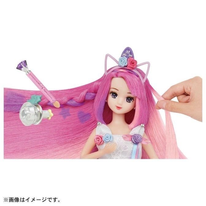  Doll with pink hair, unicorn headband, and styling accessories being styled by a hand.