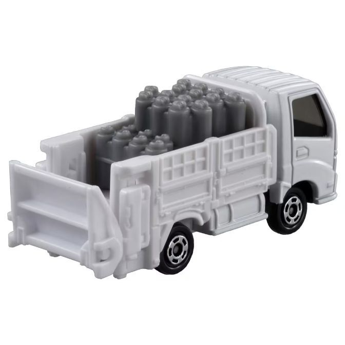  White toy truck carrying gray cylinders in its bed, featuring a detailed cab and realistic wheels.