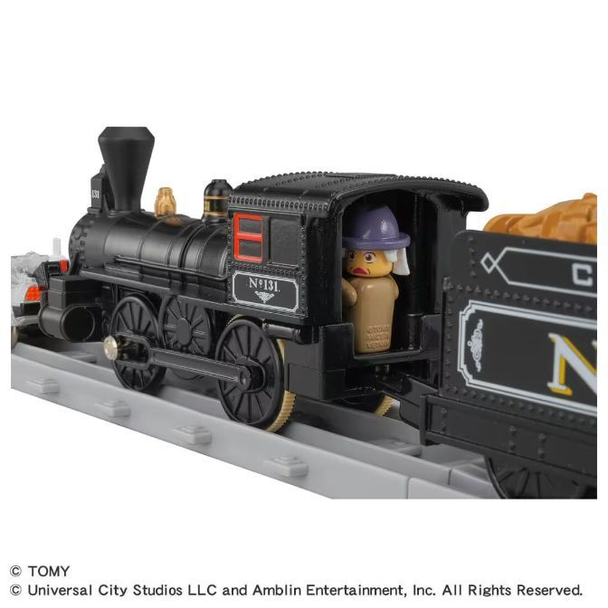  A black toy train with a figure wearing a purple hat.