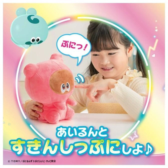  Girl interacts with a pink plush toy with a brown face, next to a blue floating toy.