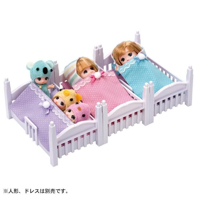  Three dolls in beds: a koala, two in animal hats, and one with blonde hair.