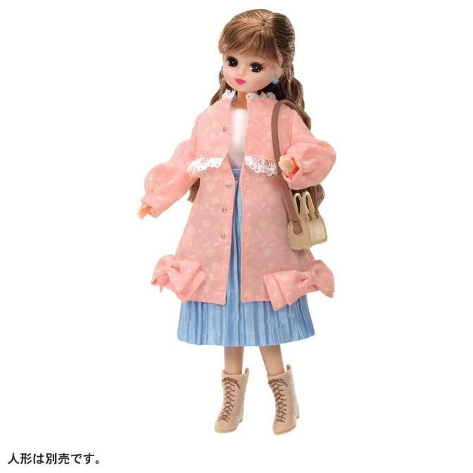Doll in pink coat, blue skirt, and boots with a purse.