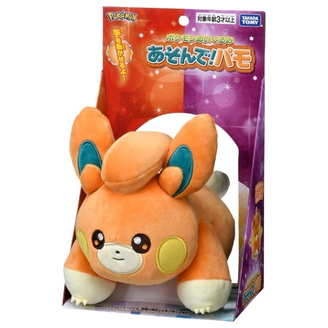 Paldea Pamo plush toy in box. Orange fur, teal ears, yellow cheeks. "Pokémon" branding visible.