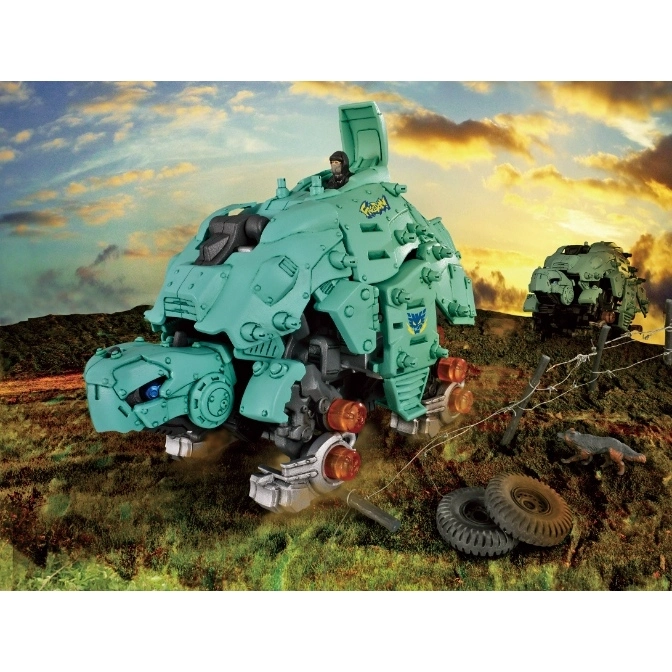  Green toy tank with a figure on a grassy field, featuring exposed wheels and mechanical details.