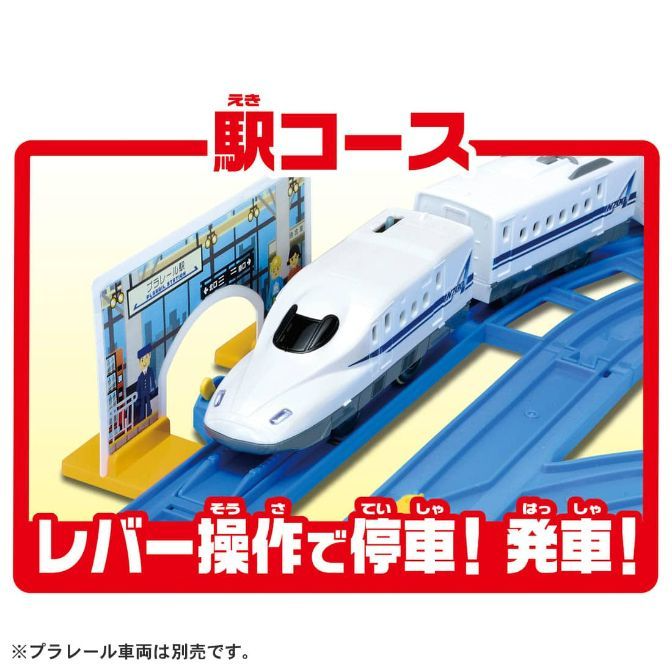  A toy train set with a white bullet train on blue tracks, a station platform, and Japanese text that translates to "Station Course" and "Stop and Start with Lever Operation."