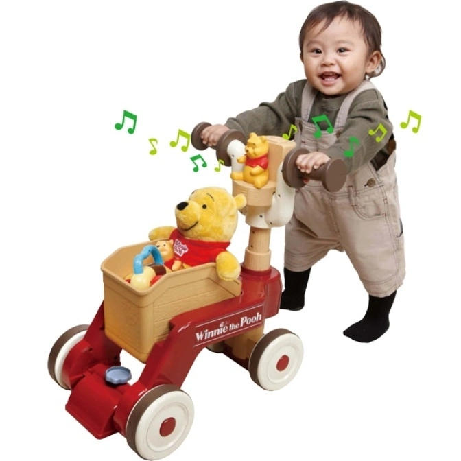 Baby pushing a Winnie the Pooh walker toy with musical notes, featuring Pooh and friends.