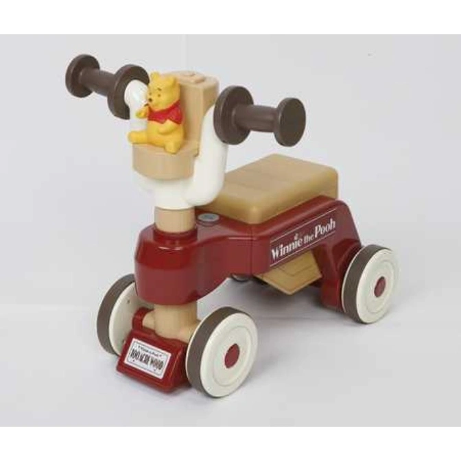  Winnie the Pooh ride-on toy with brown handlebars, seat, and wheels on a red frame.