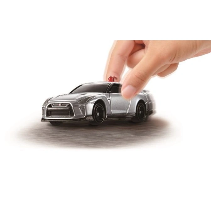 Silver toy Nissan GT-R police car with a hand on top.