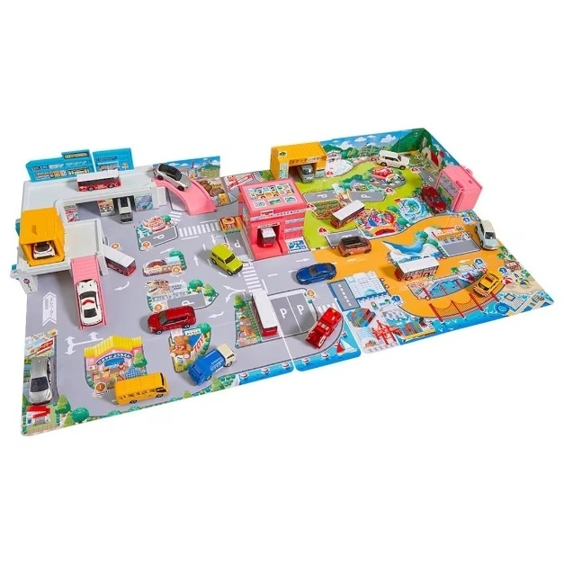  Toy car playset with buildings, roads, and miniature vehicles arranged on a playmat.