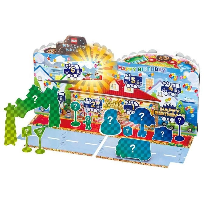 Pop-up birthday playset with toy cars, buildings, and road pieces.