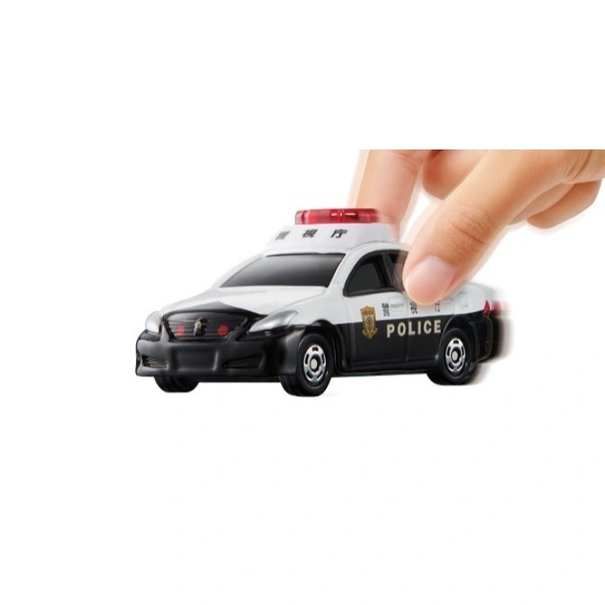 Toy Japanese police car with red light bar being pushed by a hand.