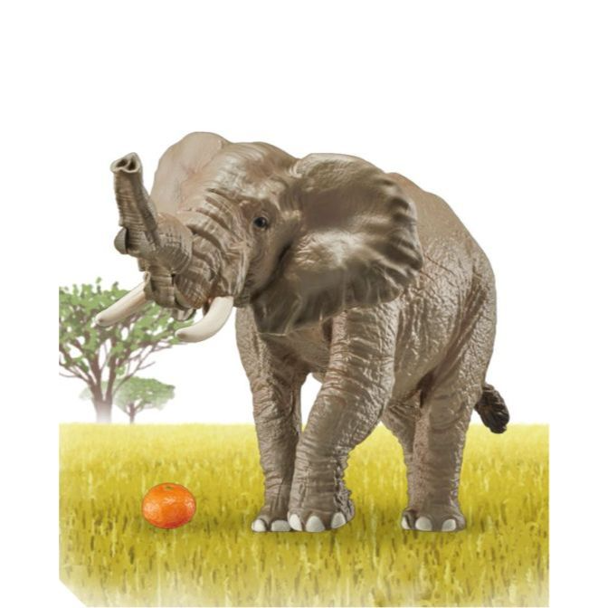 Toy elephant with raised trunk stands near an orange in a grassy field.