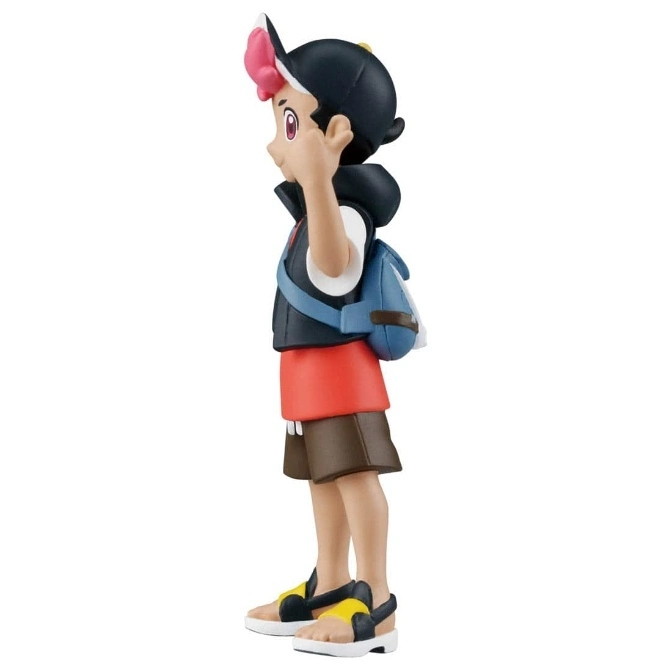  Toy figure of a boy with a backpack, wearing sandals and a cap with a pink flower.