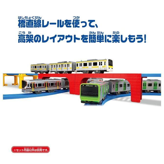  A toy train set with multiple trains on a blue track, including a yellow and white train on an elevated track, a red and silver train under a red bridge, and a green and silver train on a curved track.