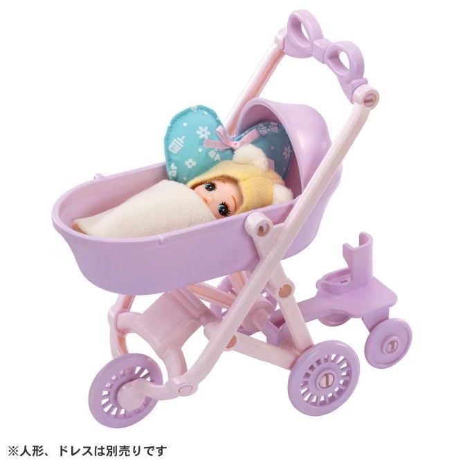  Toy baby doll in a purple stroller with a bow on the handle and heart-shaped pillow.