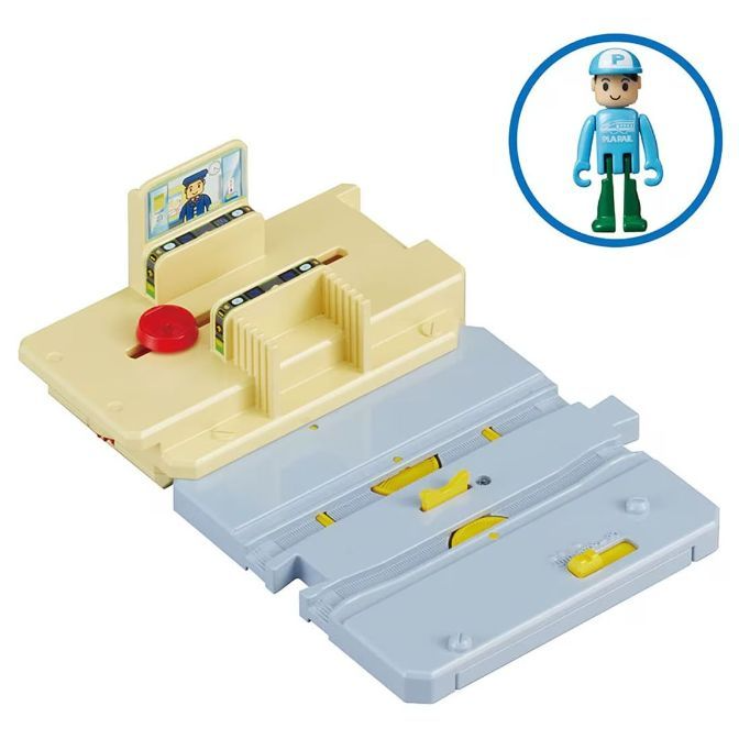 A toy train station and a toy figure of a train conductor.