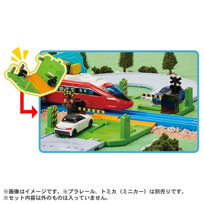  Toy train set with red train, white car, blue car, and a green ramp with a figure.