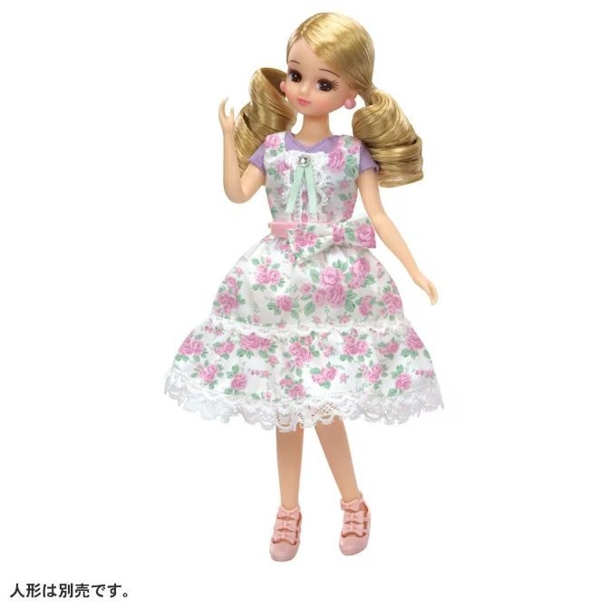  Doll with blonde hair in pigtails wearing a floral dress and pink shoes.