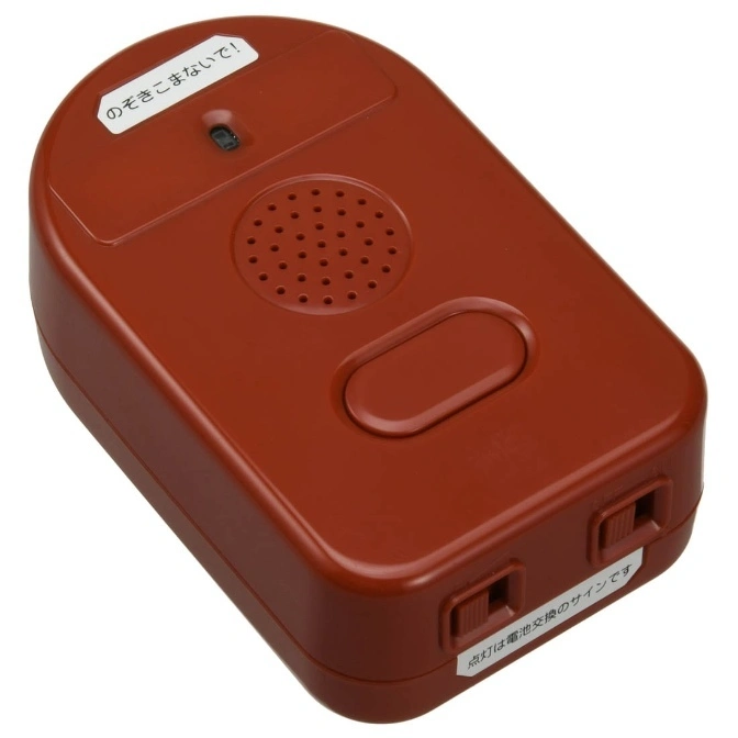  Brown electronic toy with speaker, button, and switches. Labels in Japanese.