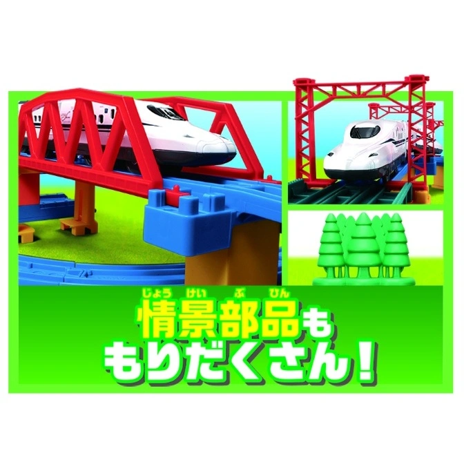  Toy train set with bullet train on a red bridge and under a red gantry, with green trees.