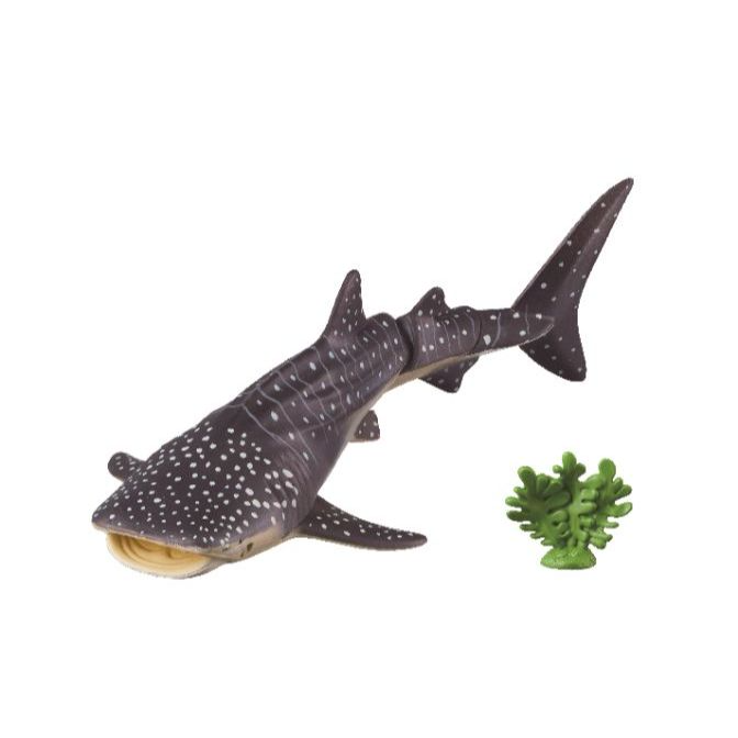 Toy whale shark with white spots and a small green coral piece.