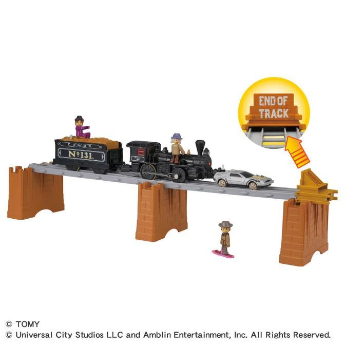  A toy train set with a train, a car, and a figure on a skateboard.