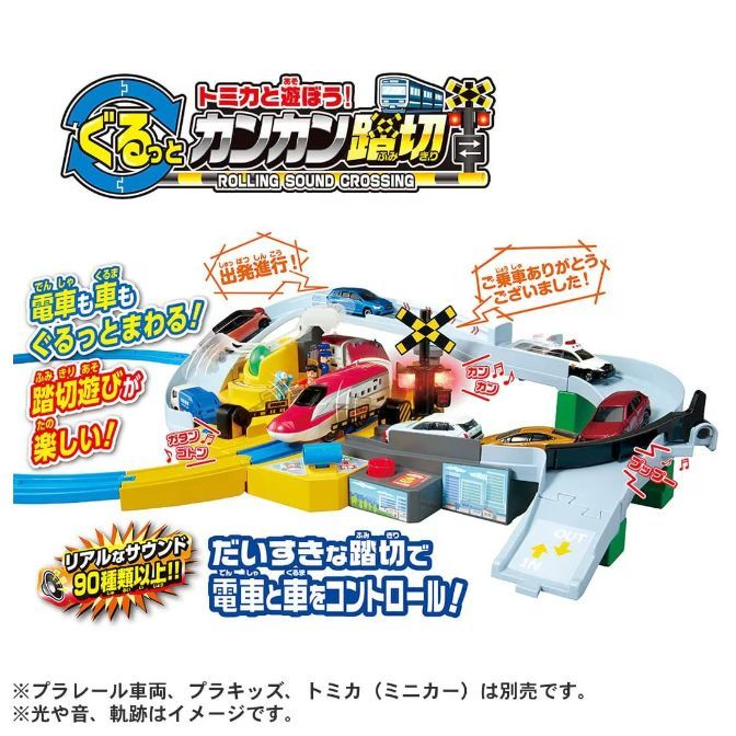  The image shows a Tomica Rolling Sound Crossing toy set. The set includes a train, cars, and a crossing gate. The train is red and white, and the cars are various colors. The crossing gate is yellow and black. The set also includes a variety of sound effects.